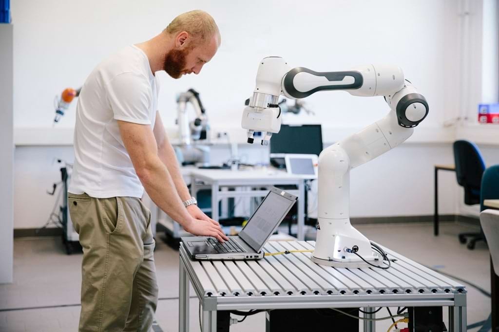 Mitarbeiter programmiert Produktionsroboter