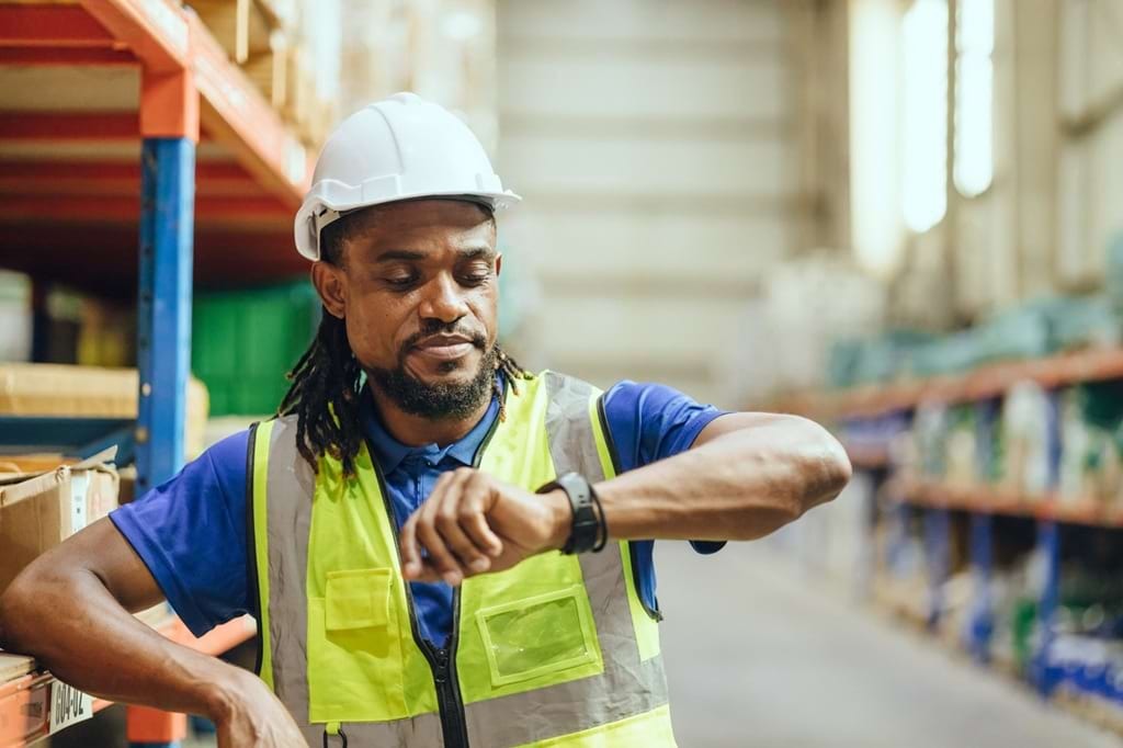 Arbeiter schaut auf die Armbanduhr