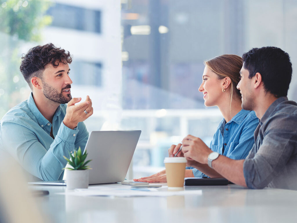 Menschen bei angeregtem Gespräch an einem Tisch; © iStock courtneyk